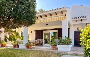 ein Haus mit einer Terrasse mit Stühlen in einem Hof in der Unterkunft 4 Bedroom Gorgeous Home In Orihuela in Orihuela