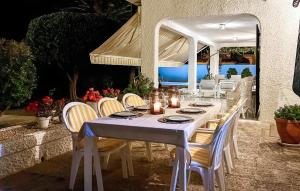 ein weißer Tisch mit Stühlen und ein weißer Regenschirm in der Unterkunft 4 Bedroom Gorgeous Home In Orihuela in Orihuela