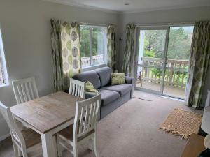 a living room with a couch and a table at Incline Cottage in Upper Hutt