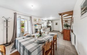 une cuisine et une salle à manger avec une table et des chaises dans l'établissement Gorgeous Home In Saint-Méloir-Des-Ondes, à Saint-Méloir-des-Ondes