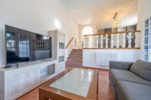a living room with a couch and a flat screen tv at Casa Bon Descans in Santa Susanna
