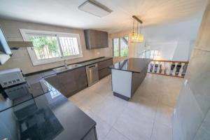 a large kitchen with a large island in the middle at Casa Bon Descans in Santa Susanna