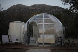 a bedroom in a glass igloo with a table and chairs at Glamping & Spa Luna Azzurra in Sulmona +15 photos