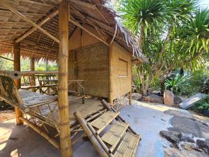a straw hut with chairs in front of it at Campchamao in Ban Ra-ok