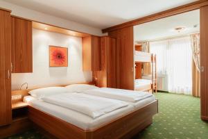Postel nebo postele na pokoji v ubytování Hotel Gratz Großarl
