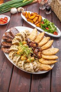 two plates of food with meat and chips on a wooden table at Khangain Tugul Hotel in Tsetserleg