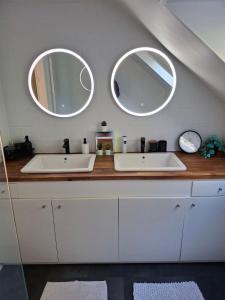 two sinks in a bathroom with two mirrors at Au pied de Lille, parking privé inclus in Lille