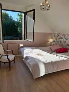 a bedroom with a bed and a chair and a window at Au pied de Lille, parking privé inclus in Lille