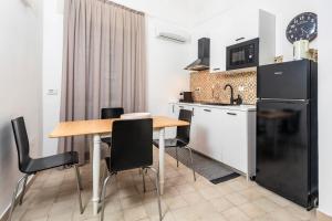 cocina con mesa de madera y electrodomésticos negros en Forti Luna, en Catania
