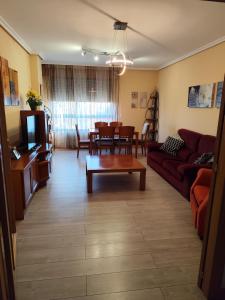 un soggiorno con un divano e un tavolo di apartamento de tres dormitorios con garaje y todos los servicios cerca a Burgos