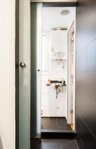 un couloir menant à une salle de bain avec un lavabo dans l'établissement Moderno y auténtico en el corazón de Poble Sec, à Barcelone