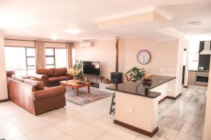 a living room with a couch and a tv at Hermanus Reefs in Hermanus