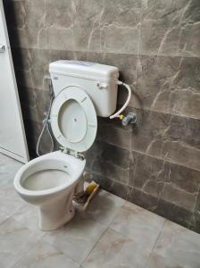 La salle de bains est pourvue de toilettes avec un couvercle. dans l'établissement Ivory Room - Compact studio, à Mumbai 46 autres photos