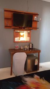 a room with a table with a television on a wall at Dunduzu Village Lodge in Katoto
