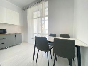 a kitchen and dining room with a table and chairs at Квартира в центре Астаны in Astana
