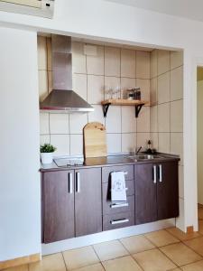 a kitchen with brown cabinets and a sink at Apartamento Rural la Fontanina TRCC0087 Complejo la Fontanina in Mata de Alcántara