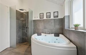a bathroom with a tub and a shower at Awesome Home In Tarm With Kitchen in Tarm +31 photos