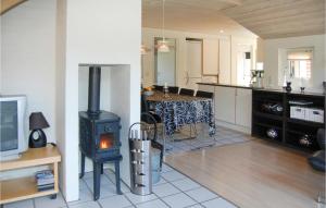 a kitchen and living room with a stove in a room at Holiday Home Guldvangen Nørre Nebel I in Lønne Hede +22 photos