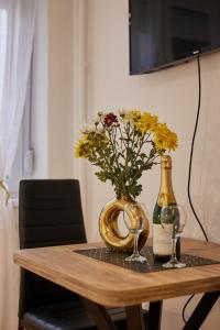 a table with a bottle of wine and a vase with flowers at Best choice Hram centar in Belgrade