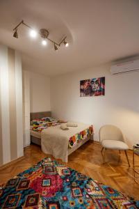 a room with two beds and a chair and a rug at Best choice Hram centar in Belgrade