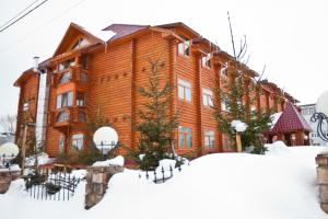 un gran edificio de madera en la nieve en Belka-Hotel, en Yuzhno-Sakhalinsk