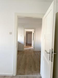 an empty hallway of an apartment with an open door at Möblierte Unterkunft im EFH mit Parkmöglichkeiten in Neulußheim