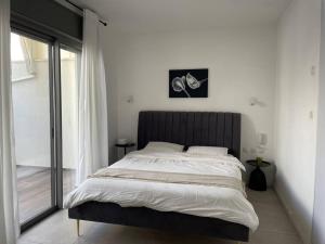 a bedroom with a large bed and a window at luxury penthouse with a jaccuzi, pool and parking, suka for Sukkot optional in H̱olon +29 photos