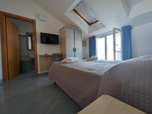 sypialnia z dużym łóżkiem i łazienką w obiekcie Hotel Doria w mieście Bellaria-Igea Marina