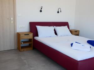 un lit avec tête de lit rouge dans une chambre dans l'établissement Louloudi Hills Villa 3, à Koskinou