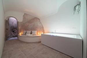 a bathroom with a bath tub with candles in it at Torre del Califfo Amalfi Relais in Amalfi +36 photos