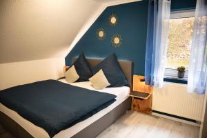 a bedroom with a bed with blue walls and a window at Rhön & Relax Zur Schustermühle - Whirlpool in Burkardroth