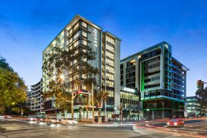 two tall buildings on a city street at night at Quest Chatswood in Sydney