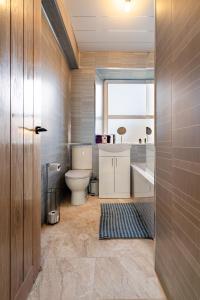 a bathroom with a toilet and a tub and a sink at 2 Bed Flat - Town Centre in Paisley