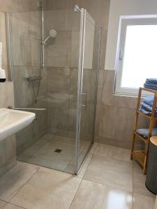 een douche met een glazen deur in een badkamer bij MP Apartments in Hückelhoven +24 foto's