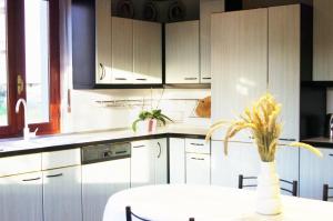 a kitchen with white cabinets and a table with a plant at QuickHome Villa Il Tiglio in Vigliano Biellese