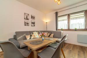 a living room with a table and a couch at Apartament Cztery Pory Roku Białka Tatrzańska in Białka Tatrzanska