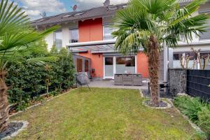a house with a palm tree in the yard at Köln-Pulheim Saphier Haus I15 min Köln Messe Lanxess I 180m2 über 4 Level I Komfort I P I Palmengarten I Babybett in Pulheim