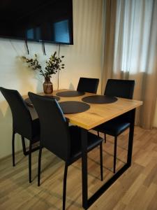 a wooden table with chairs and a vase on top at Venla in Ylivieska