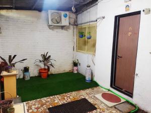 a room with a green floor and a door at Ivory Room, AC, Smart TV, Ensuite, Independent Homestay in Mumbai