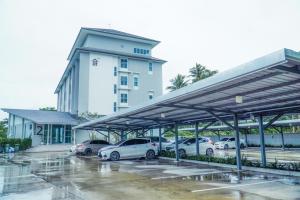un parking avec des voitures garées devant un bâtiment dans l'établissement BM Pattani, à Kampong Rusamileh 10 autres photos
