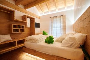 a bedroom with a large white bed in a room at Brocheta Guest House, immersa nella natura in Chies dʼAlpago
