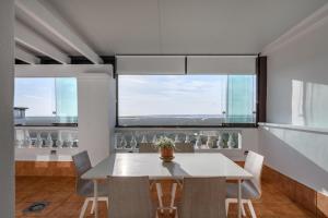 une salle à manger avec une table et des chaises et deux fenêtres dans l'établissement Las Marismas Atico PLUS by Ĥ - Isla Canela Golf GLHM59P19, à Isla Canela