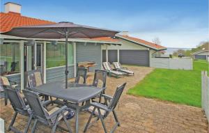 a table with chairs and an umbrella on a patio at Golfparken in Løjt