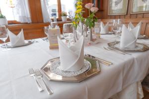 a table with a white table cloth with paper boats on it at Hotel - Restaurant Traube in Neuffen