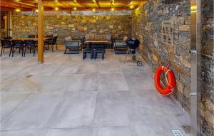 a room with a stone wall and tables and chairs at 3 Bedroom Lovely Home In Gazi, Heraklio in Lygaria +8 photos