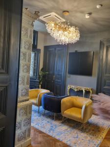 a living room with two chairs and a chandelier at Heritage Boutique in Caracal