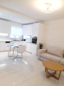 a white living room with a couch and a table at White Dome Apartment I in Souda