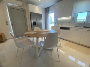a kitchen with a table and chairs in a room at White Dome Apartment I in Souda