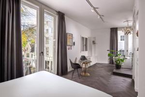 a bedroom with a bed and a large window at Boutique Hotel DARQ in Maastricht