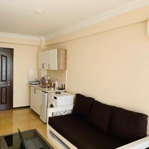 a living room with a couch and a kitchen at Mgzavrebi Apartments in Kvariati